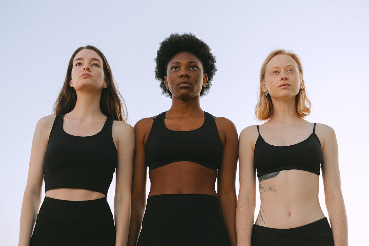 Three diverse women confidently standing together, symbolizing empowerment and unity.