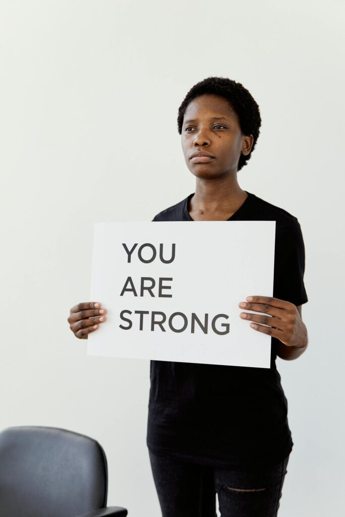 pexels photo 8384905 8384905 A person holds a 'YOU ARE STRONG' sign, promoting empowerment and resilience.